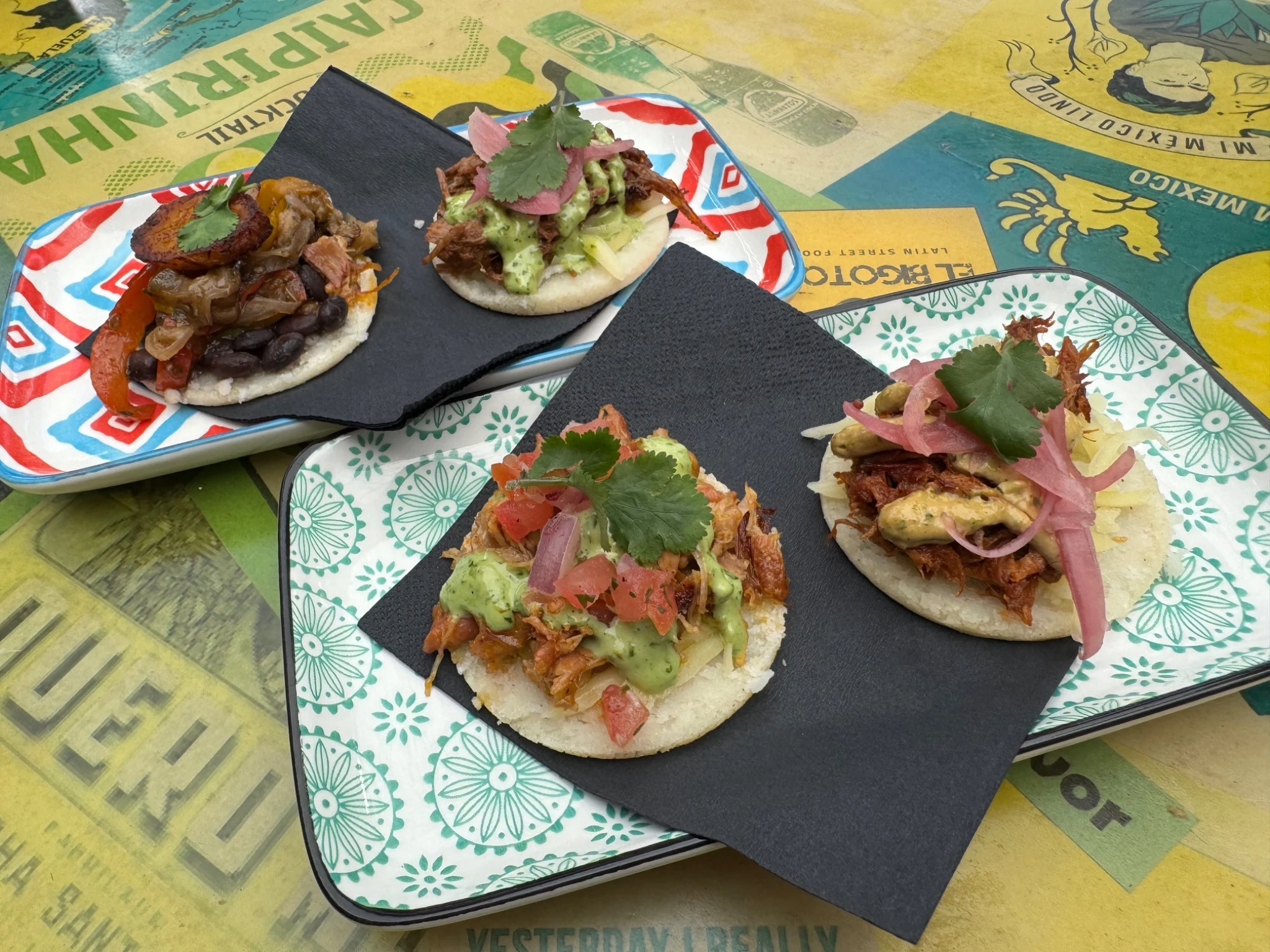 Colourful topped arepas on patterned plates