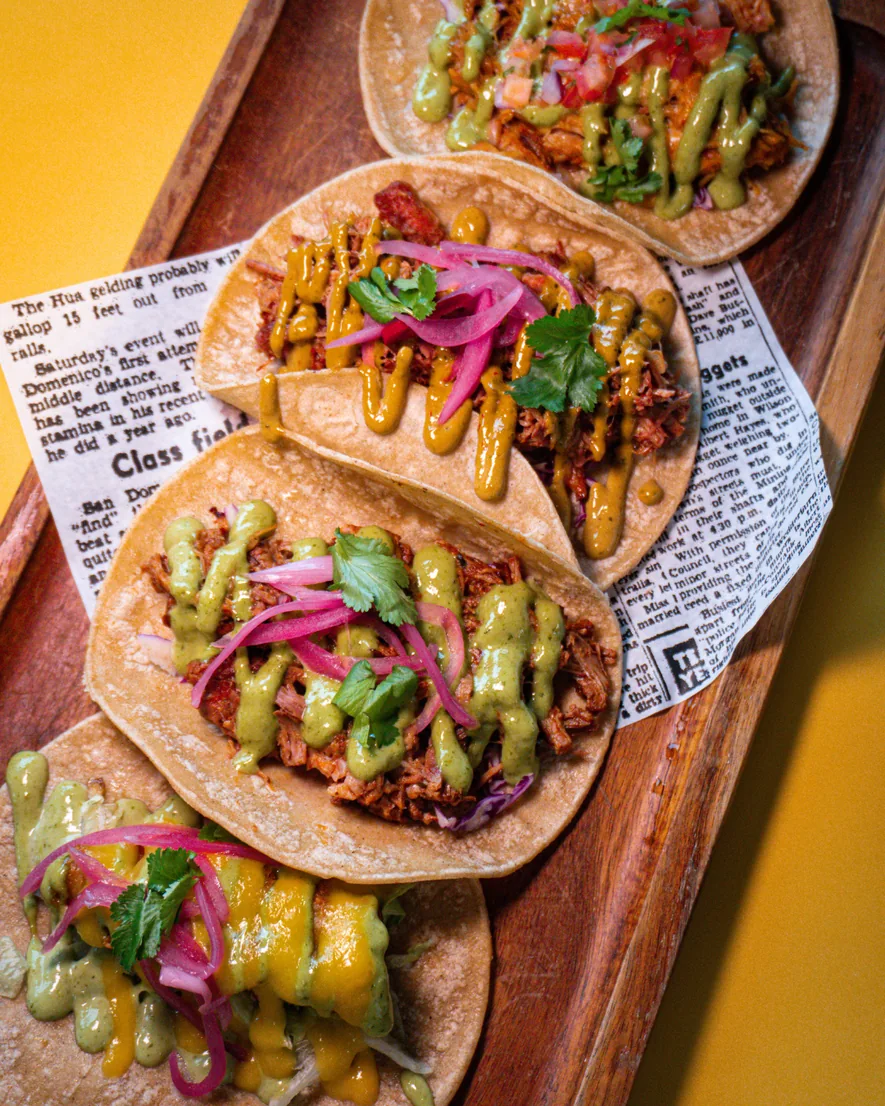 Colourful El Bigoton tacos served on a wooden board